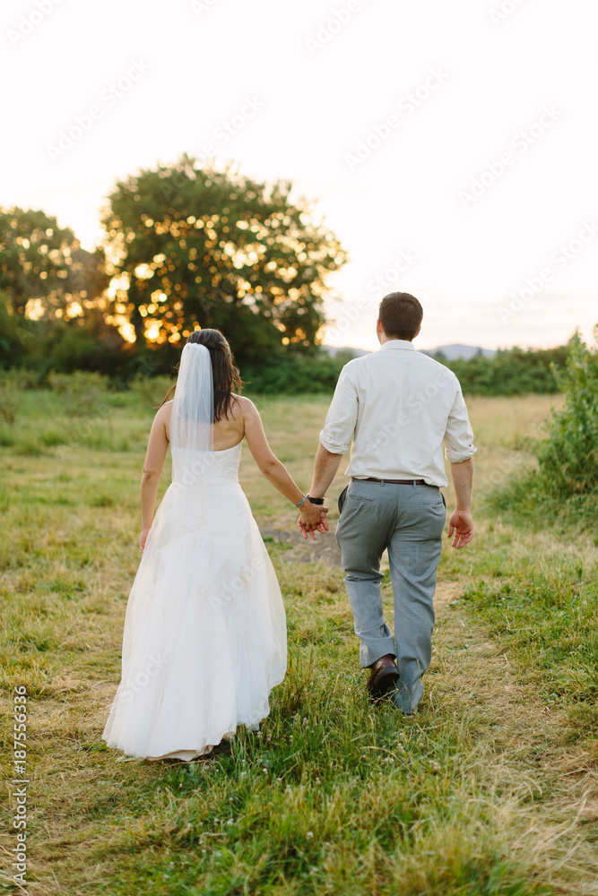Bride and Groom Walking around Farm at Sunset Bride and Groom Walking around Farm at Sunset
