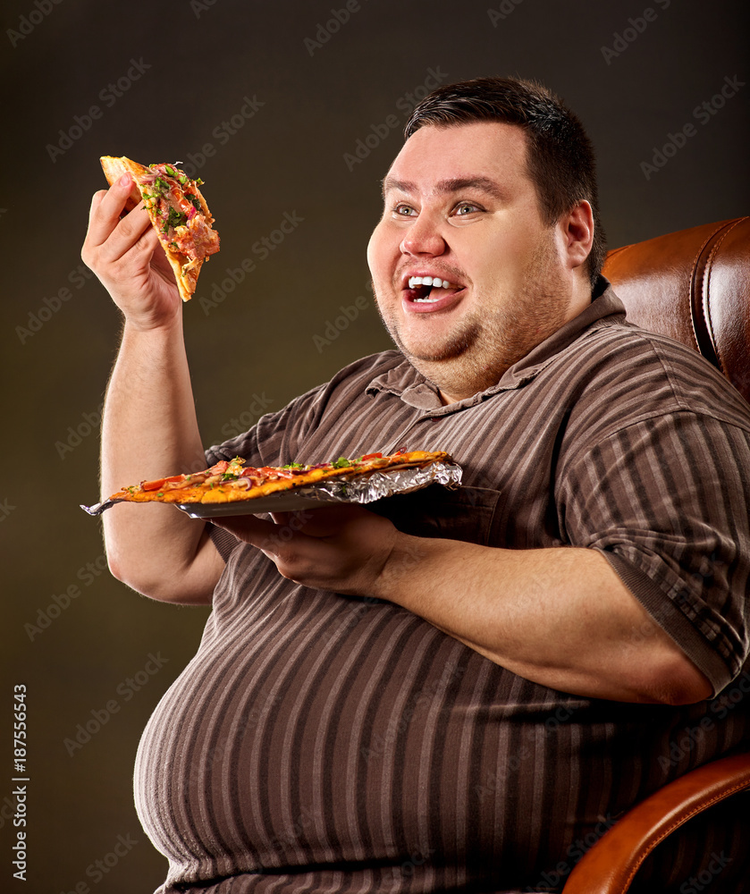 Fat man eating fast food and offers great pizza to customers . Male treats chic junk meal to