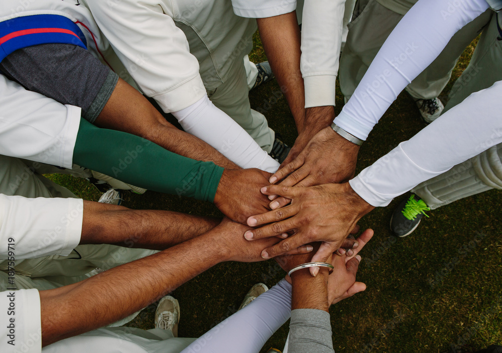 A group of anonymous people placing their hands together A group of anonymous people placing their hands together