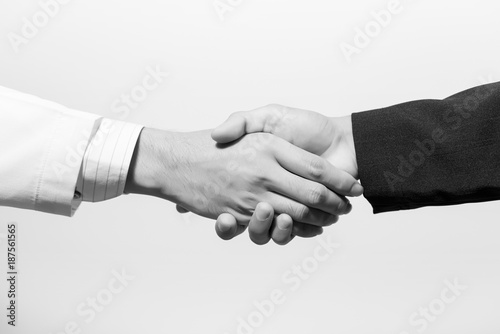 Man doctor and her lawyer shaking hands on white. black and white.
