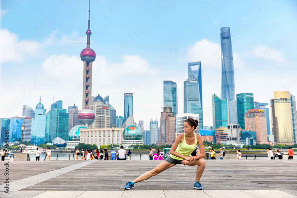 Fototapeta premium Biegacz kobieta rozciąganie nóg w miejskim mieście