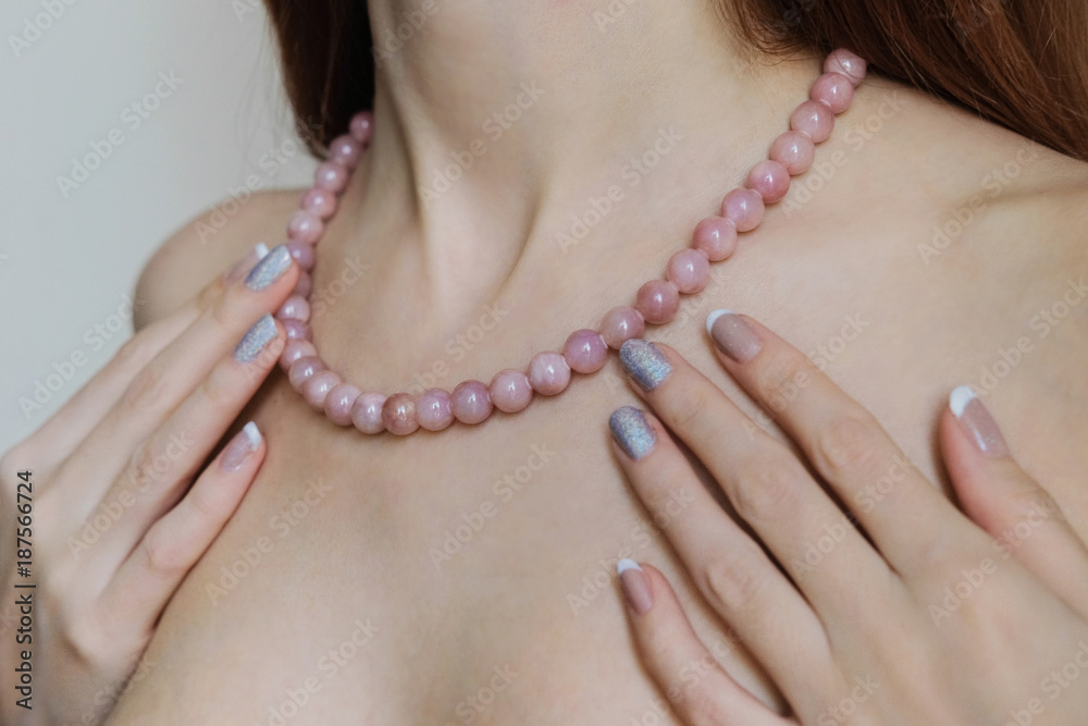 Pearl necklace on the neck of the girl. Advertising jewelry. The pearl strand.
