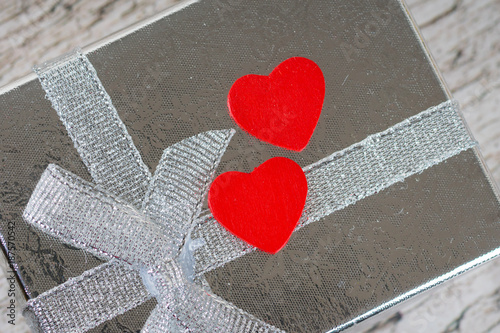 two red hearts on silver gift box