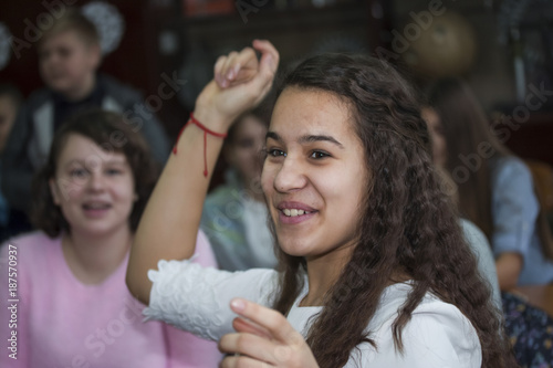young girl student in excitement raises her hand in class