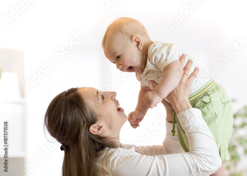 Happy mother raising baby a...