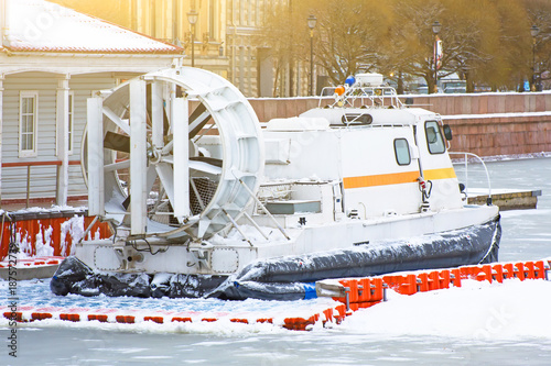 Rescue hovercraft at the pier at the frozen river in winter.