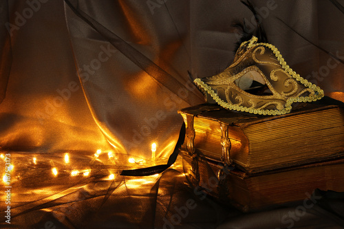 Image of elegant gold and black venetian mask over tulle background.