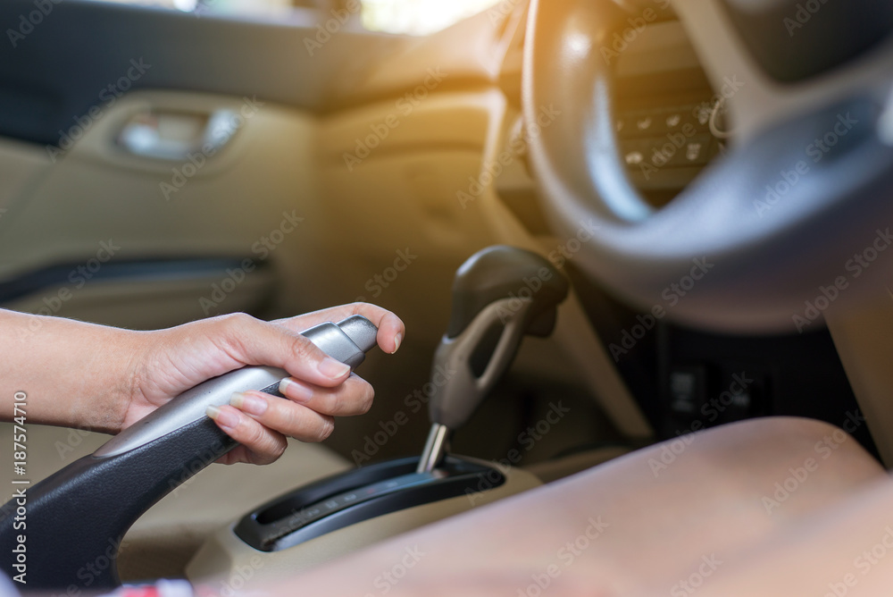 Hand driver pulling the hand brake inside car
