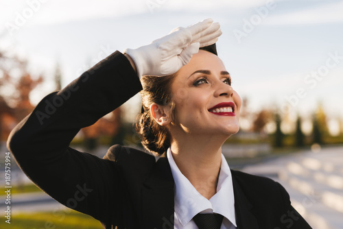 Billede på lærred happy young stewardess girl looks up at the sky