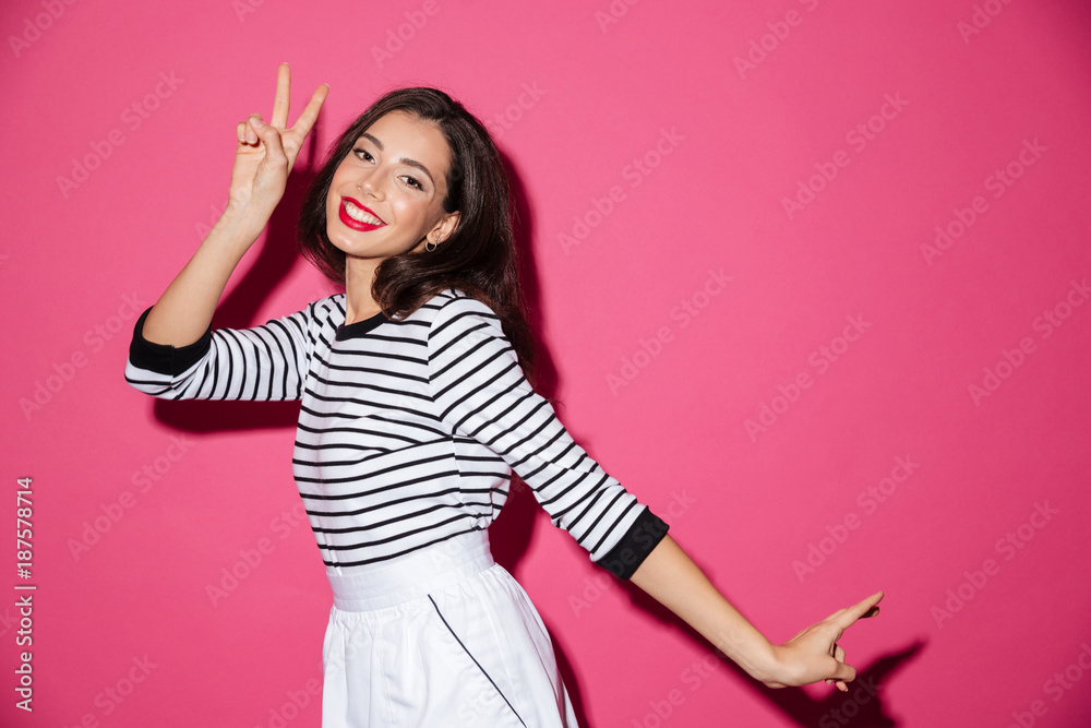 Portrait of a smiling woman showing peace gesture Portrait of a smiling woman showing peace gesture
