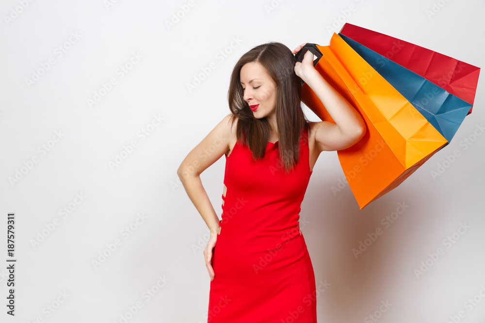 Attractive glamour caucasian fashionable young brown-hair woman in red dress holding multi colored packets with purchases after shopping isolated on white background. Copy space for advertisement. Attractive glamour caucasian fashionable young brown-hair woman in red dress holding multi colored packets with purchases after shopping isolated on white background. Copy space for advertisement.