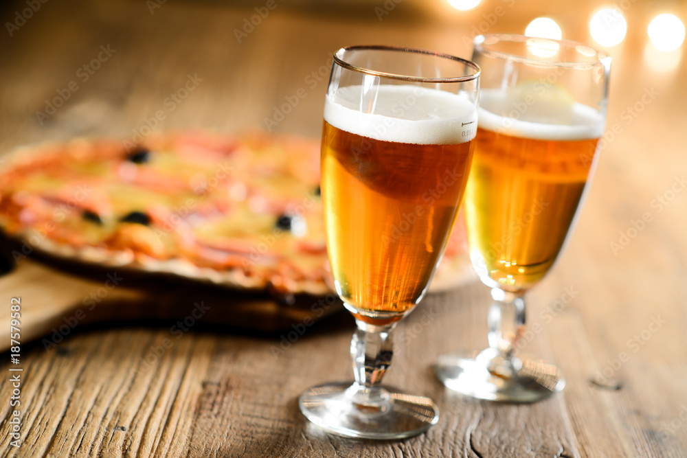 fresh beer and pizza on wood restaurant table indoor with cosy dim light fresh beer and pizza on wood restaurant table indoor with cosy dim light