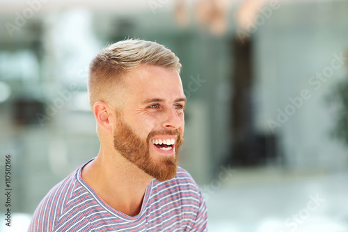 young man with beard laughing