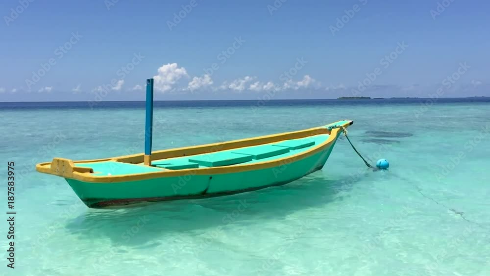 Small colourful boat docked near a tropical beach Small colourful boat docked near a tropical beach