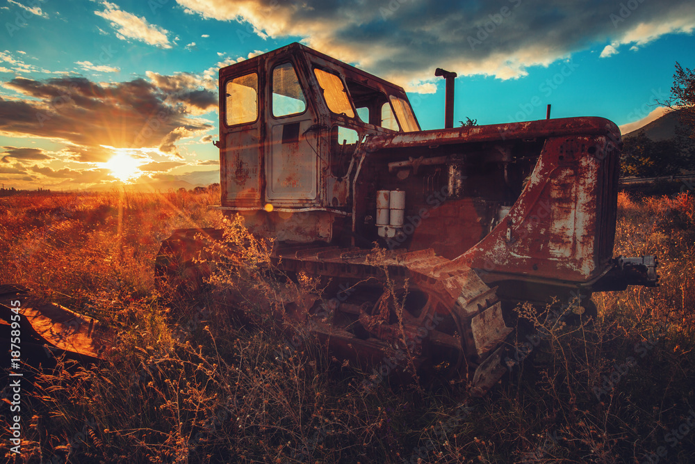 HDR image of old rusty tractor in a field. Sunset shot