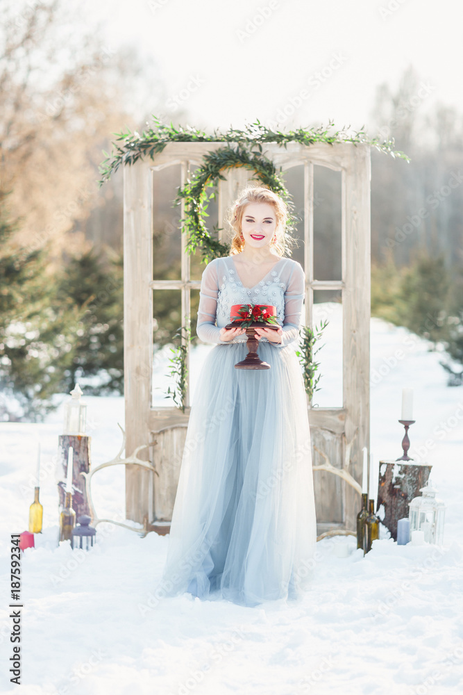 Bride in a blue wedding dress holding a cake. Bride in a blue wedding dress holding a cake.
