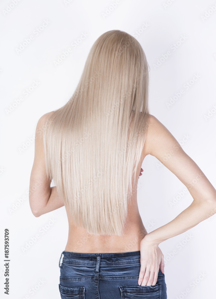 Naklejka premium Sexy shot from the back. Girl with perfect blonde hair posing in a jeans.