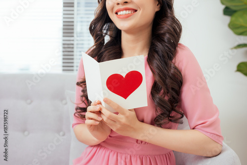 Cute girl reading a love card from her boyfriend