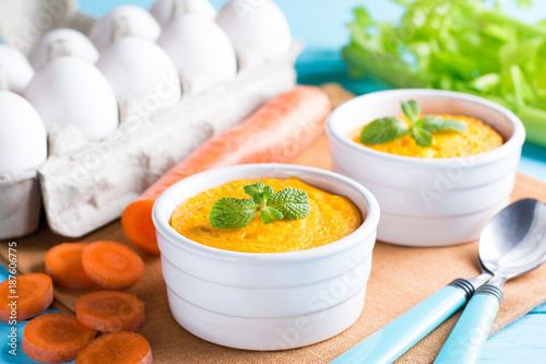Canvastavla Ramekins with tasty carrot souffle on wooden table