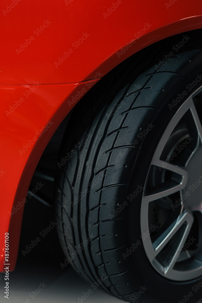 cropped shot of wheel of red sport car