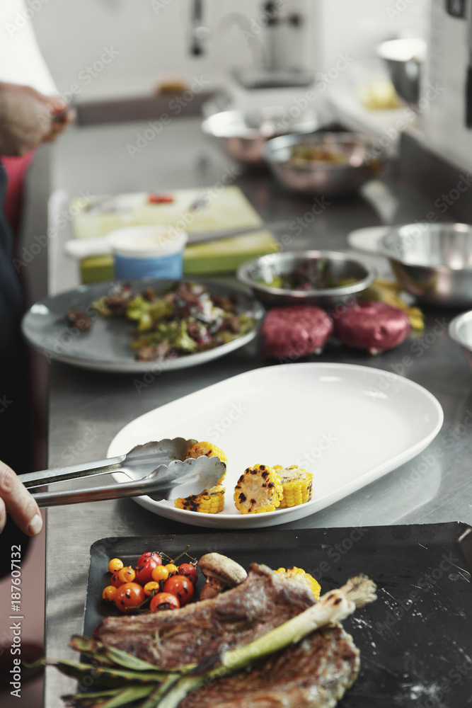 Chef cooking juicy beef steak at restaurant kitchen