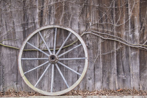Altes Wagenrad lehnt an einer Scheunenwand