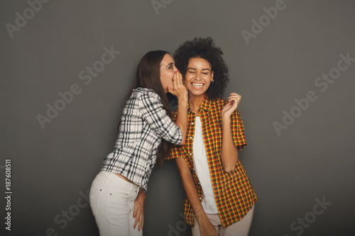 Obraz na plátně Young woman telling her friend some secrets