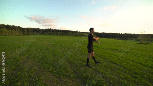 Wallpaper Mural Young athlete doing exercises in beautiful meadow at sunset. Moving the camera. 4K Torontodigital.ca