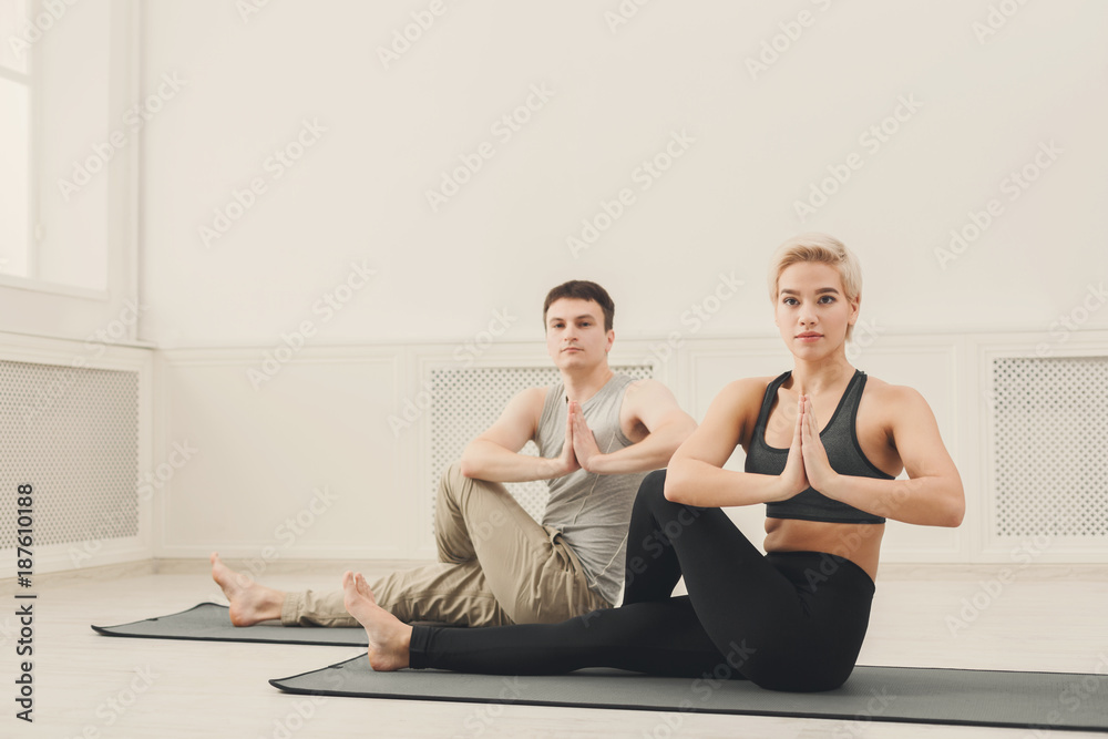 Young couple practicing yoga sitting in padmasana Young couple practicing yoga sitting in padmasana