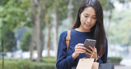 Wall Mural Woman use of mobile phone and shopping bag