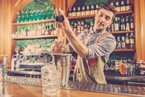 Expert barman is making cocktail at night club. © master1305