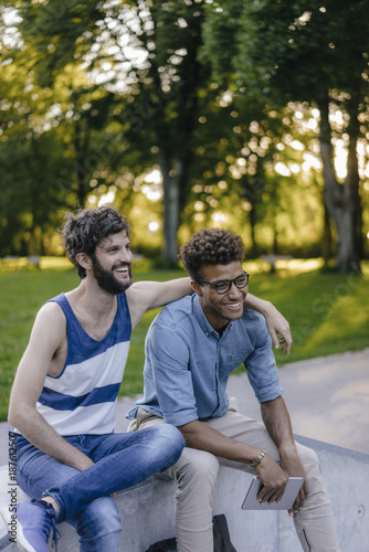 Two happy friends sitting in a skatepark © Westend61