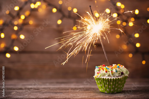 cupcake with sparkler on old wooden background