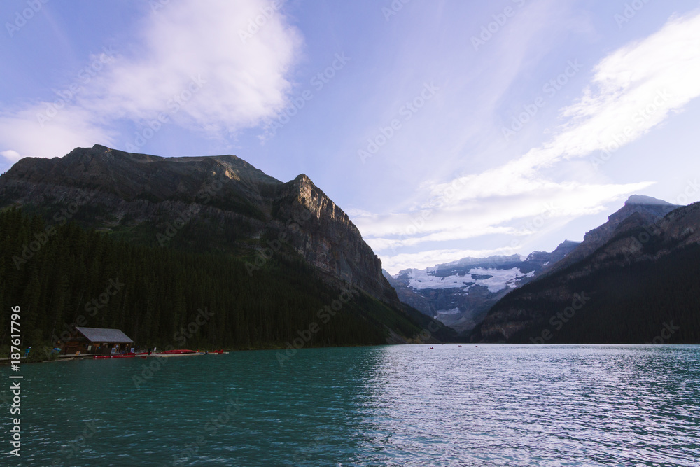 People on canoe on Lake Louise in Rocky Mountains while last light during sunset