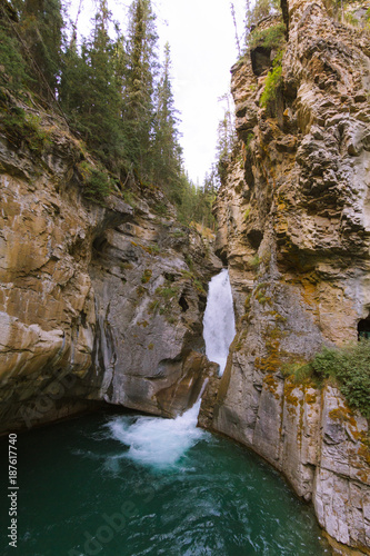 Glacier green river and falls in rocky landscape in Rocky mountains in Canada