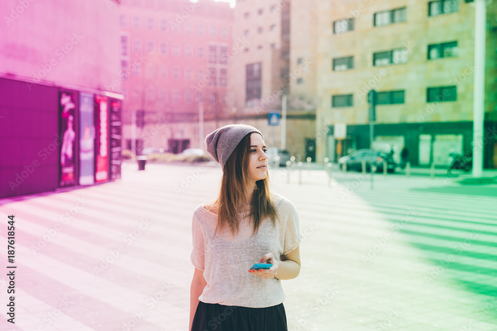 Fototapeta premium Young woman outdoor using smart phone hand hold looking away - technology, social network, phubbing concept
