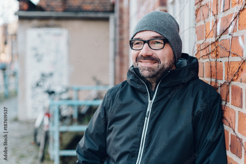 Obraz premium Thoughtful man smiling as he stares ahead