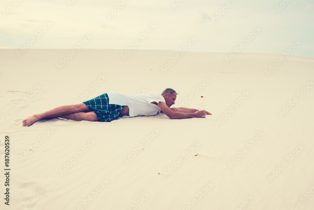 Exhausted man, lost in the desert, crawls on the sand Exhausted man, lost in the desert, crawls on the sand