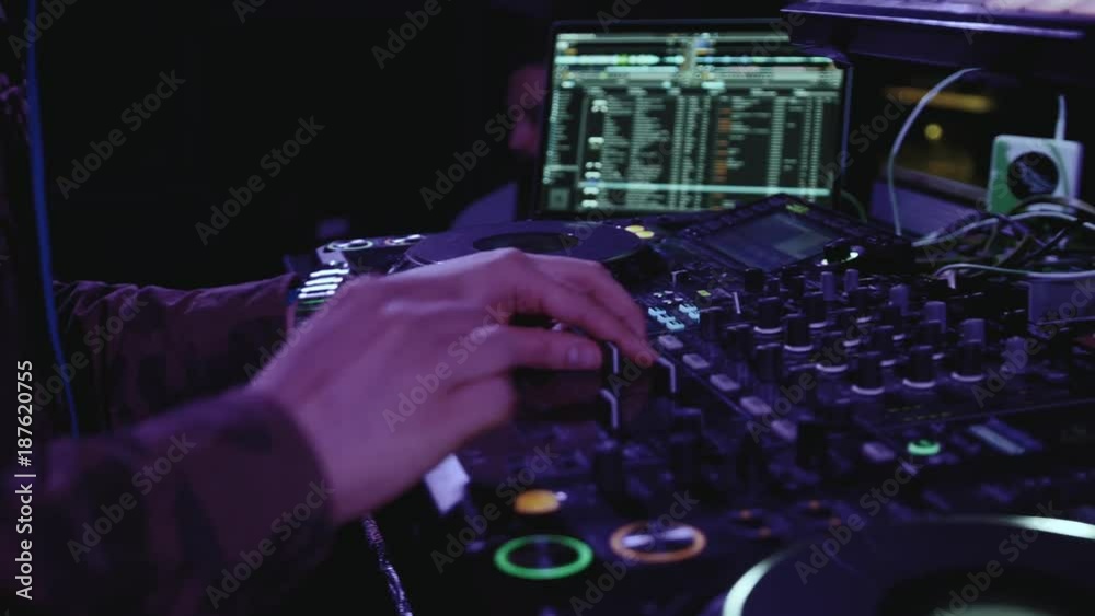 Close up of dj playing party music on modern cd usb player in disco club - Nightlife and entertainment concept - Defocused background with shallow depth of field and focus on buttons near mixing hand