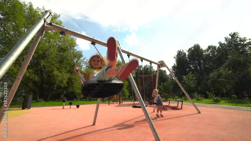 Two little sisters ride on the swings at the playground 4K Two little sisters ride on the swings at the playground 4K