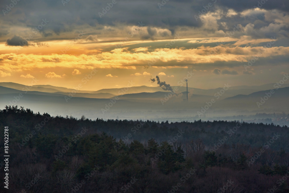 Fototapeta premium Smog hell - sunset. View from afar the city and a factory chimney with lots of smoke and smog. Europe, landscape Slovakia, Novaky. Chemical factory. Abstract. Global warming of the earth.