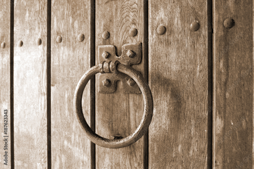 Detail of retro door knocker on a wooden gate Detail of retro door knocker on a wooden gate