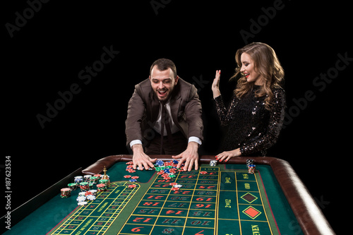 Man with woman playing roulette at the casino. Addiction to the  photo