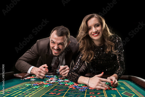 Man with woman playing roulette at the casino. Addiction to the  photo