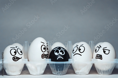 Faces on chicken eggs in the form of facial expressions, reflecting emotions. The concept of racism, misunderstanding, a barrier in relations, denial of society. Barriers between people, prejudice. photo