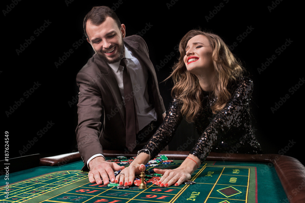 Man and woman playing at roulette table in casino Man and woman playing at roulette table in casino