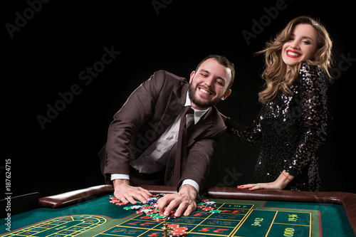 Man with woman playing roulette at the casino. Addiction to the  photo