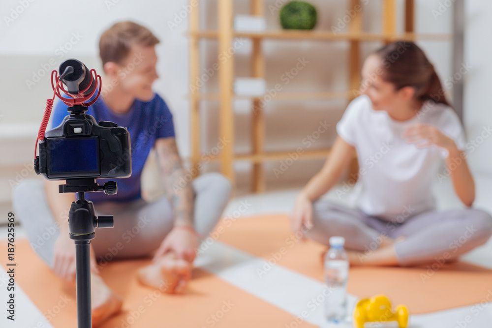 Recording together. Cheerful young friendly bloggers feeling happy while sitting in front of a camera and enjoying their talk Recording together. Cheerful young friendly bloggers feeling happy while sitting in front of a camera and enjoying their talk
