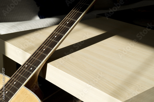 Acoustic guitar neck in sunshine with contrast shadow