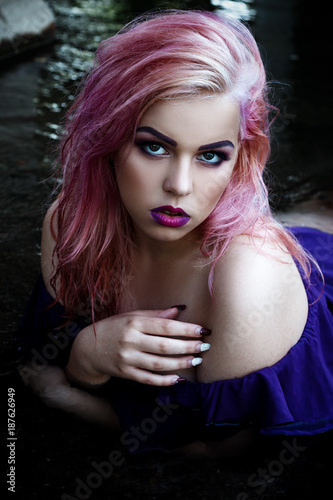 Foto A coveted sexy girl in a purple dress and beautiful make-up, passionately posing